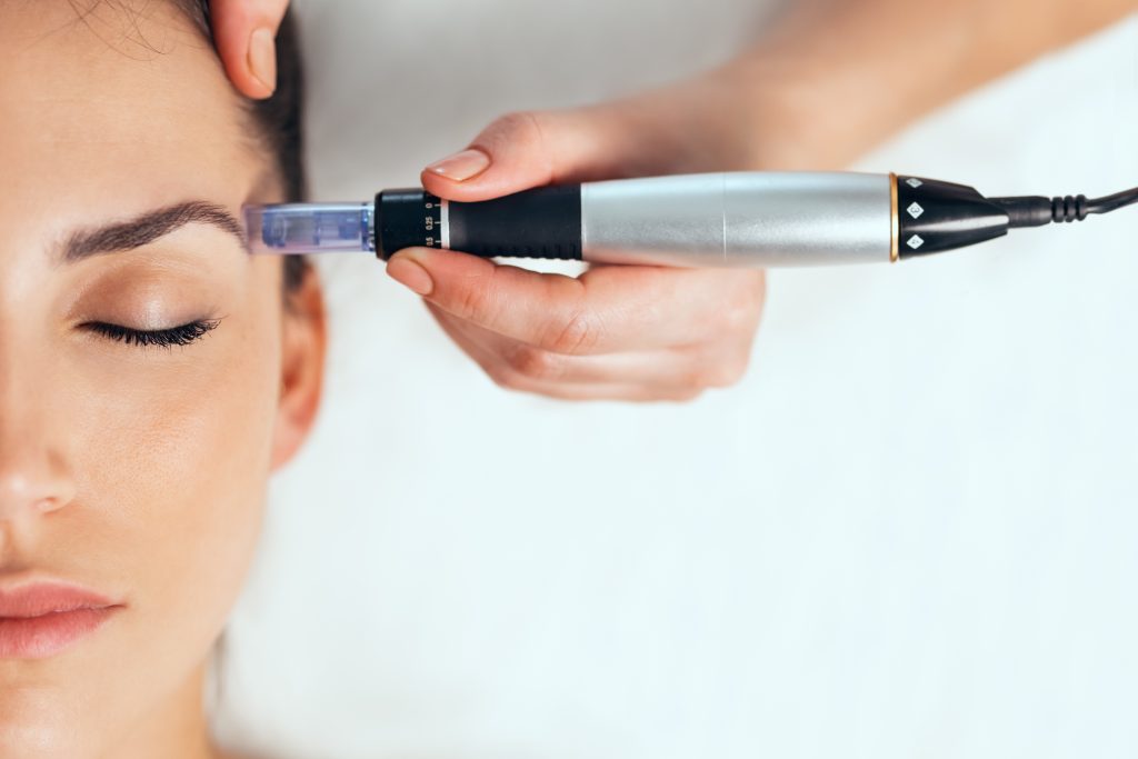 Cosmetologist making mesotherapy injection with dermapen on face